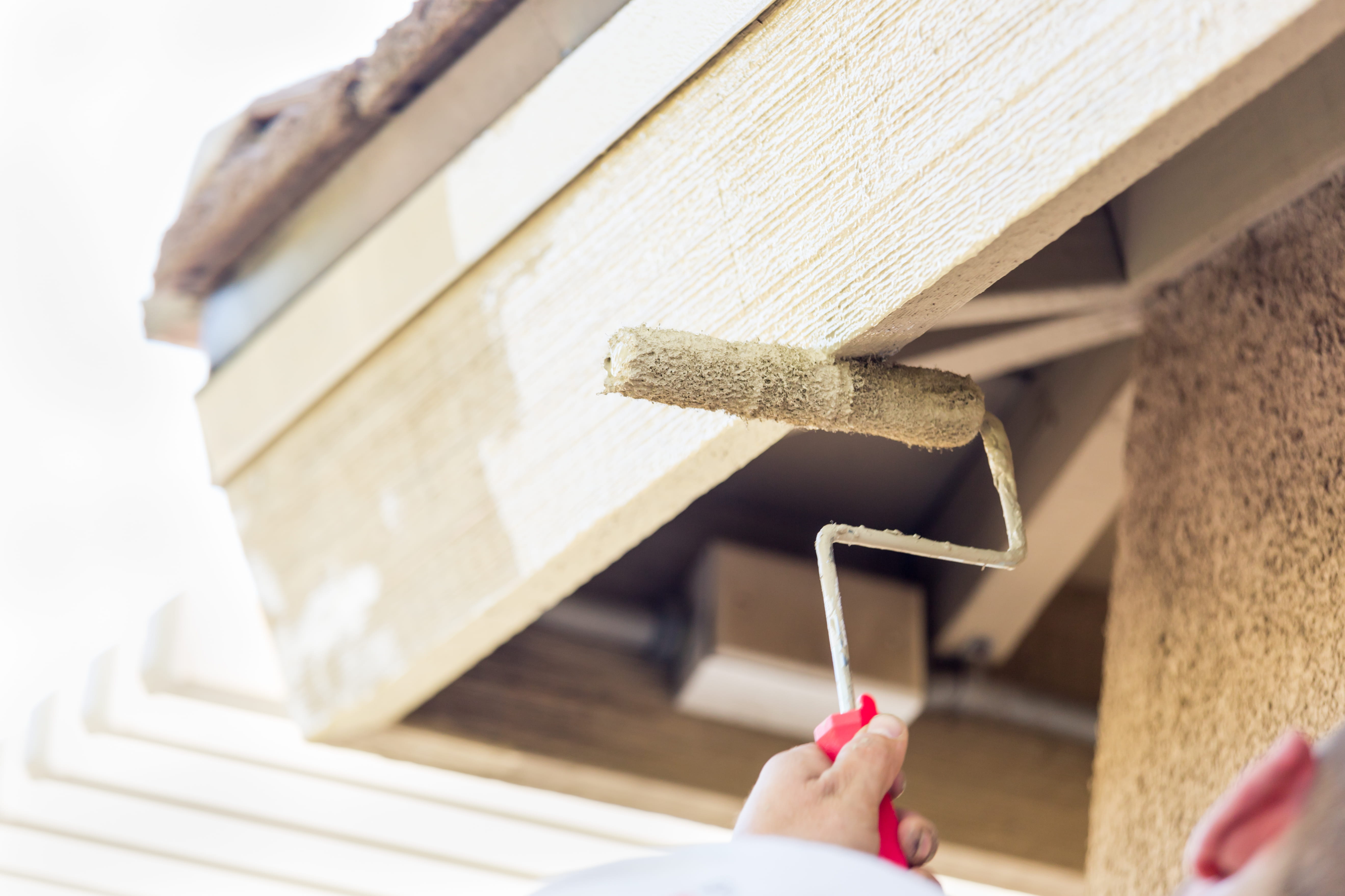 Exterior wall being painted with roller