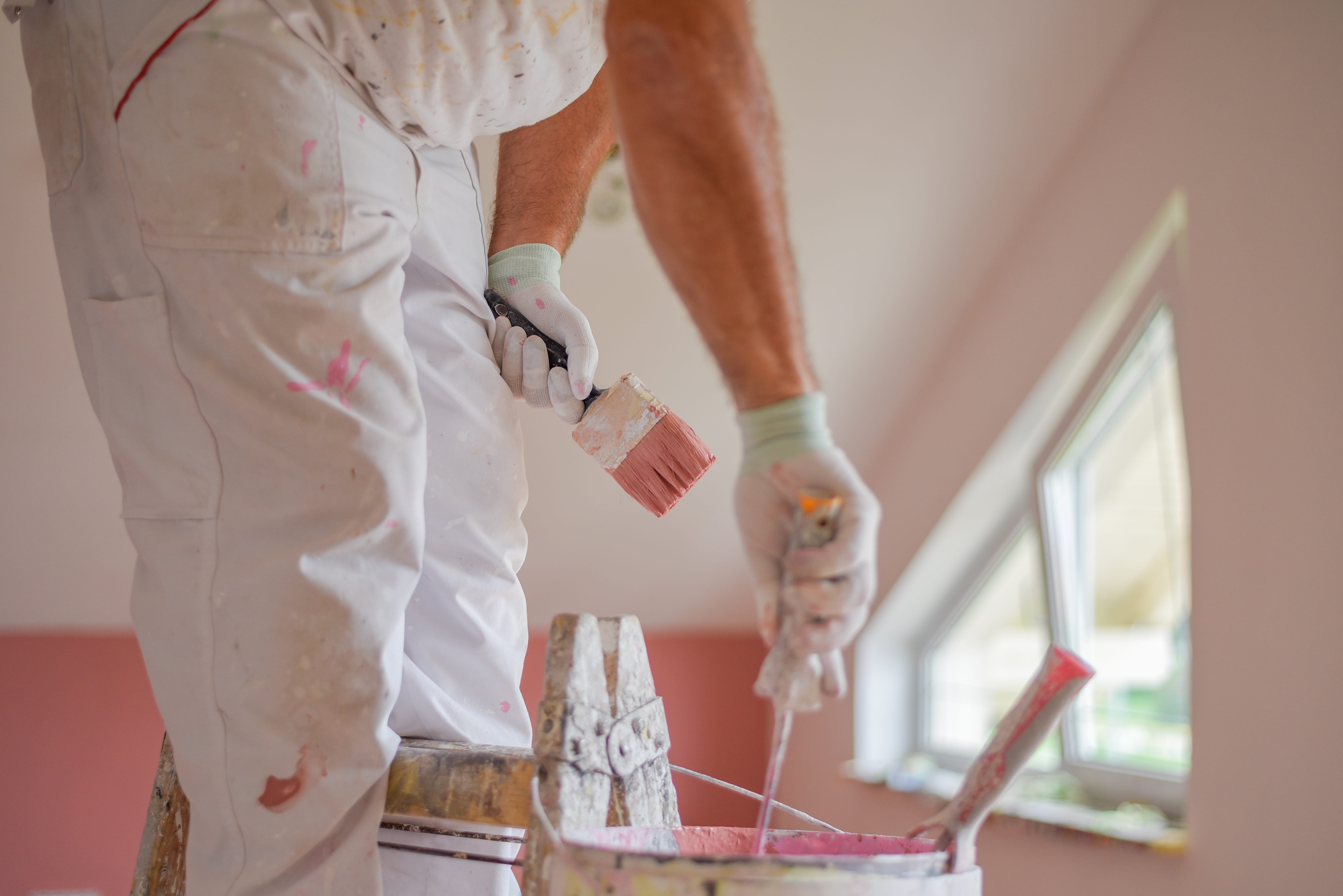 Residential painter applying interior paint to a family home