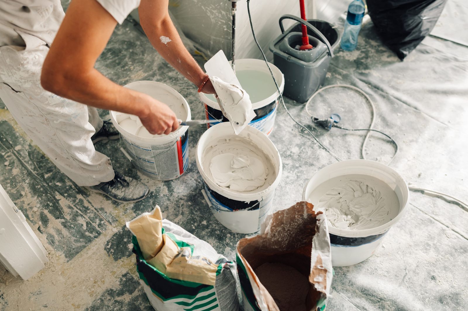 Filling and smoothing a plastered wall surface with a trowel before priming and painting